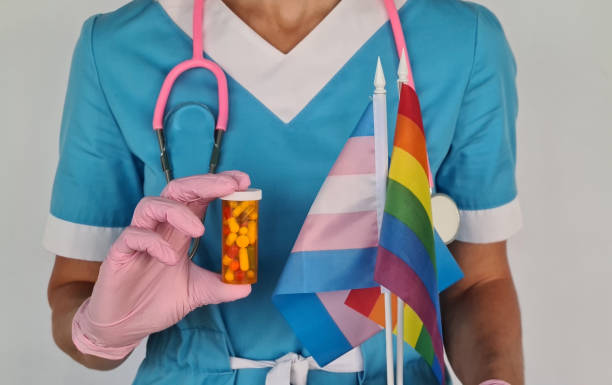 Hormonal pills after gender reassignment. Rainbow LGBT pride badge and flag in the hands of a doctor