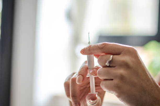 Hormone therapy. Menopause treatment. Close-up of woman's hands using injections for hormone replacement therapy.